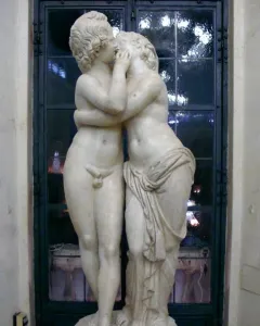 Cupid and Psyche marble sculpture showing two youthful figures embracing and kissing.