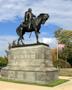 Custer equestrian statue on a stone pedestal with CUSTER carved on the front