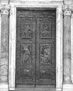 The Filarete Door at St. Peter’s Basilica, shown as an ornate set of double bronze doors with relief panels and fluted columns.