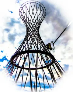 Mae West sculpture silhouetted against a bright cloudy sky with blue patches.