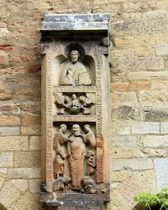Weathered stone relief of the Tomb of Bruno the Priest, showing stacked figural scenes and vertical inscriptions on a wall.