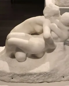 Metamorphoses, a white marble sculpture of two nude figures in an intertwined embrace.