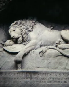 Lion Monument in Lucerne showing a dying lion carved into a rock grotto with a broken spear and shield.