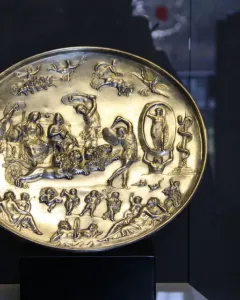 The Parabiago Plate, a gold-toned circular relief with a central chariot scene and surrounding mythological figures.