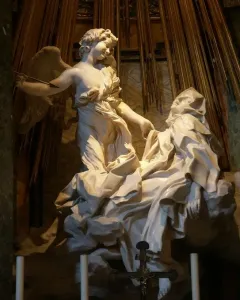 The Ecstasy of Saint Teresa by Bernini, showing a winged angel and a reclining woman beneath golden rays.