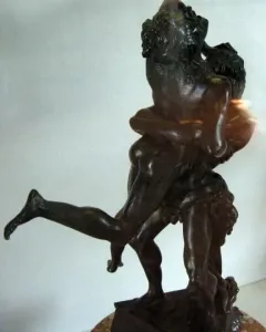 Hercules and Antaeus bronze sculpture showing two muscular figures in a struggle on a marble pedestal.