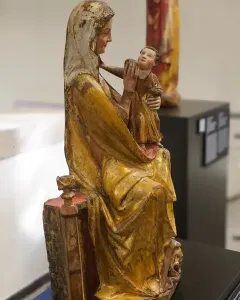 Virgin on a Wide Throne, a weathered wooden sculpture of a seated robed woman holding a child.