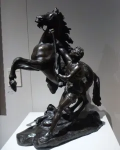 Marly Horses bronze sculpture of a rearing horse and a muscular man wrestling it with a staff.