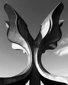 Stone Flower, a large concrete sculpture with curved petal-like forms rising against a cloudy sky.