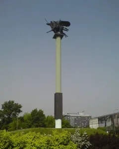 Polish Cavalry Monument on a tall pillar above a grassy mound, with dark horse and rider figures at the top.