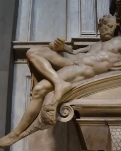 Michelangelo’s Evening, a reclining marble male figure with a bearded face in the Medici Chapel.