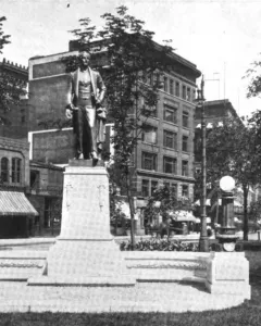 Stevens T. Mason Monument with a bronze figure on a tall stone pedestal in an urban park setting.