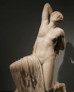 The Niobid from the Gardens of Sallust, a pale marble sculpture of a kneeling female figure with one arm raised behind her head.