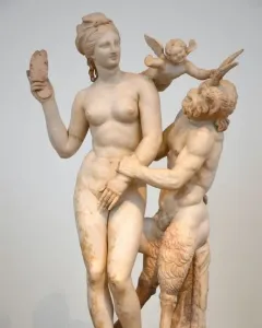 Marble sculpture of Aphrodite, Pan and Eros, with a nude woman resisting Pan as Eros pushes him away.