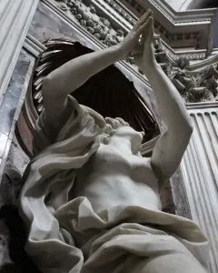 Bernini\'s Daniel and the Lion marble sculpture with raised arms in an ornate niche