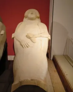 Lady of Cádiz stone sculpture of a woman with curly hair and hands resting over her midsection.