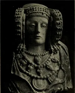 Stone bust of the Lady of Elche with an ornate headdress and layered necklaces.