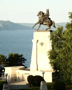 Tatishchev Monument showing a rider on a rearing horse atop a tall stone pedestal by the water.