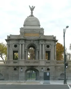 Hurlbut Memorial Gate with a stone arched entrance, cupola, and eagle statue on top.