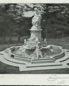 The Lorelei Fountain, a stone fountain with a standing figure on a tall pedestal and smaller figures in a stepped basin, set in a wooded park.