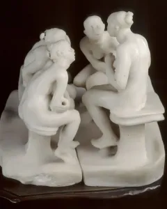 The Confidence marble sculpture showing four seated women in two facing pairs against a dark background.