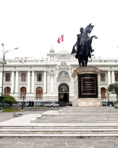 Equestrian statue of Simón Bolívar on a rearing horse in a paved plaza, with the Congress building in the background.