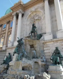 Fountain of King Matthias with bronze figures in front of a palace facade in Budapest