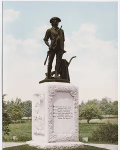 The Minute Man bronze statue of a colonial militiaman holding a musket beside a plow on a stone pedestal in a park.
