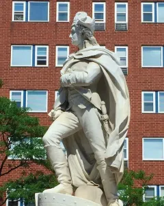 George Washington marble statue in military attire standing on a pedestal