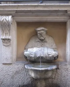 The Porter fountain statue of a bearded man in a cap pouring water from a barrel into a basin.