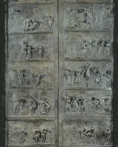 Bernward Doors with tall bronze relief panels showing multiple narrative scenes and lion-head knockers.