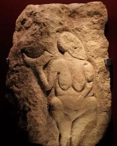 Venus of Laussel stone relief of a nude female figure holding a crescent-shaped object.