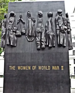 The Women of World War II monument with eleven relief figures and gold lettering.