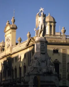 Genio Catalán Fountain with a winged male figure holding a star atop its pedestal and seated figures around the base
