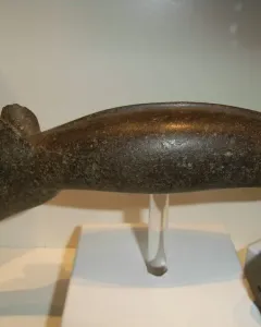 The Alunda Moose stone sculpture displayed on a clear stand with a white base.