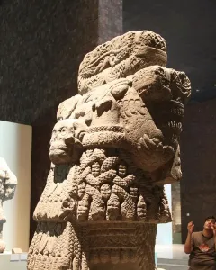 Coatlicue stone statue with serpent heads, skull necklace, and carved textured body