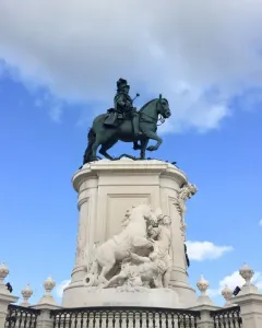 Equestrian statue of Joseph I on a tall ornate pedestal against a blue sky.