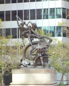 Mechanics Monument bronze sculpture of muscular men operating industrial machinery on a stepped stone pedestal.