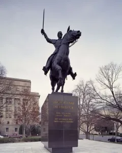 Simón Bolívar equestrian statue of a man in military uniform raising a sword while mounted on a rearing horse.