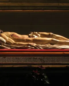 Cristo Yacente, a recumbent sculpture of Christ lying on a raised platform with visible wounds.