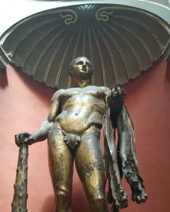 Hercules standing in a shell-shaped niche, holding a club and a lion skin, with a fig leaf covering his groin.