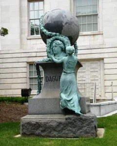 Daguerre Memorial granite monument with a bronze bust framed by a wreath, a draped female figure, and a globe on top