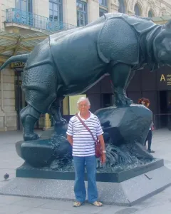 Jacquemart rhinoceros sculpture standing on a rock base outside a museum entrance