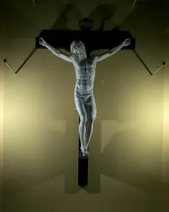 Benvenuto Cellini crucifix in white marble, showing Christ on a dark cross with INRI at the top.
