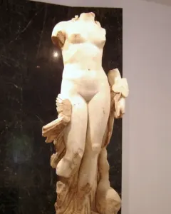 Venus Unica, a headless white stone female nude statue on a rectangular base.