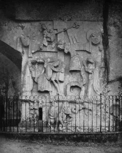 Externsteine Relief carved into a rocky cliff face, showing draped figures around a central cross.