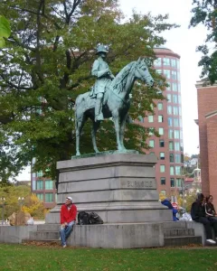 Ambrose Burnside Monument showing an equestrian bronze statue on a stone base inscribed Burnside, with people seated on the steps nearby.