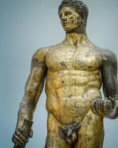 Hercules of the Forum Boarium, a gilded bronze nude male statue holding a club and three round objects.