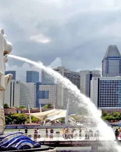 The Merlion statue spouts water into the bay with Singapore’s skyline behind it.