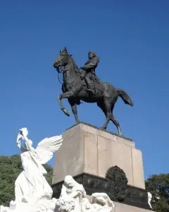 Bartolomé Mitre Monument showing a dark equestrian sculpture atop a tall stone pedestal with carved figures at the base.